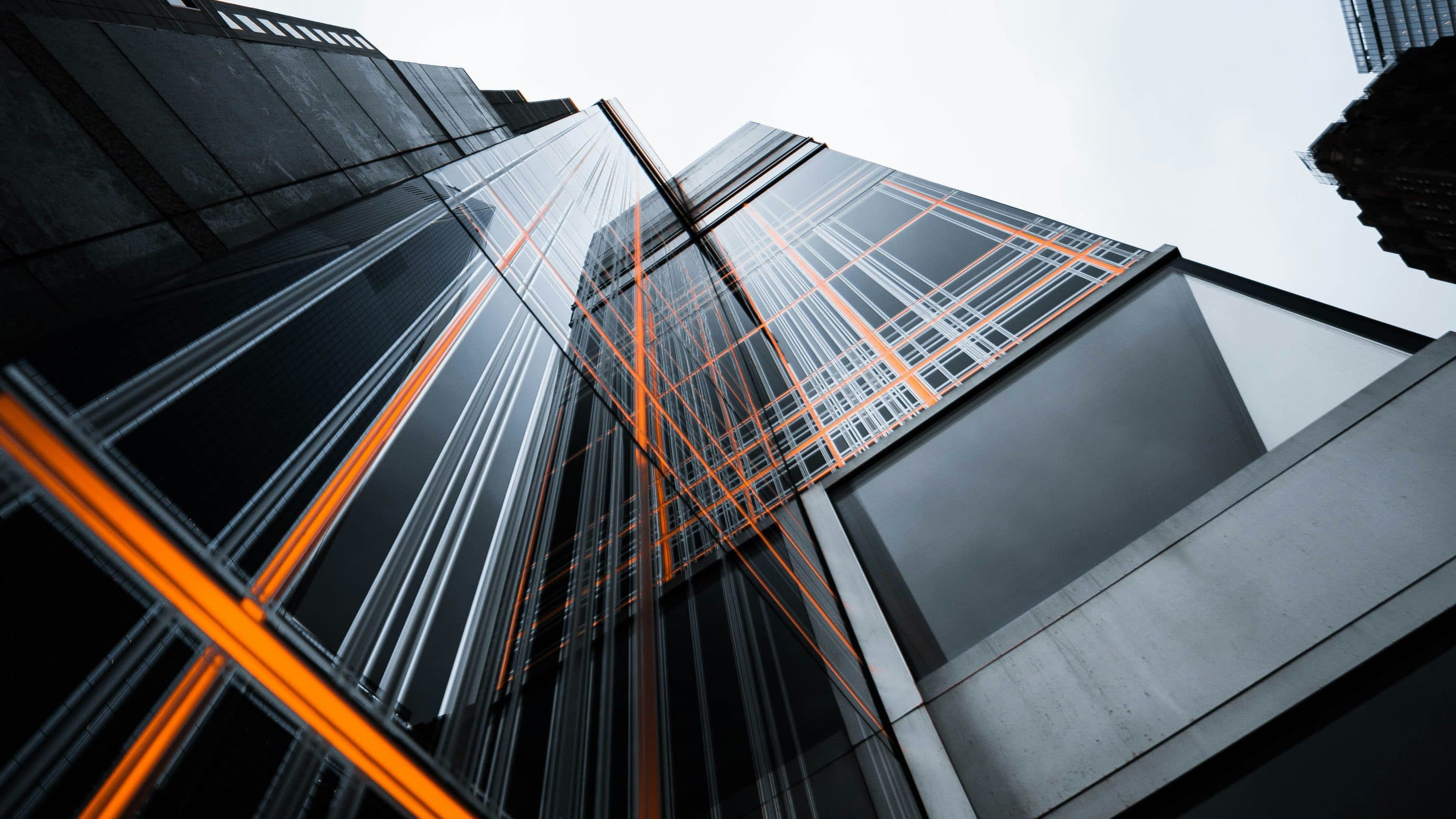 Glass towers seen from below, crossed by orange lines of light